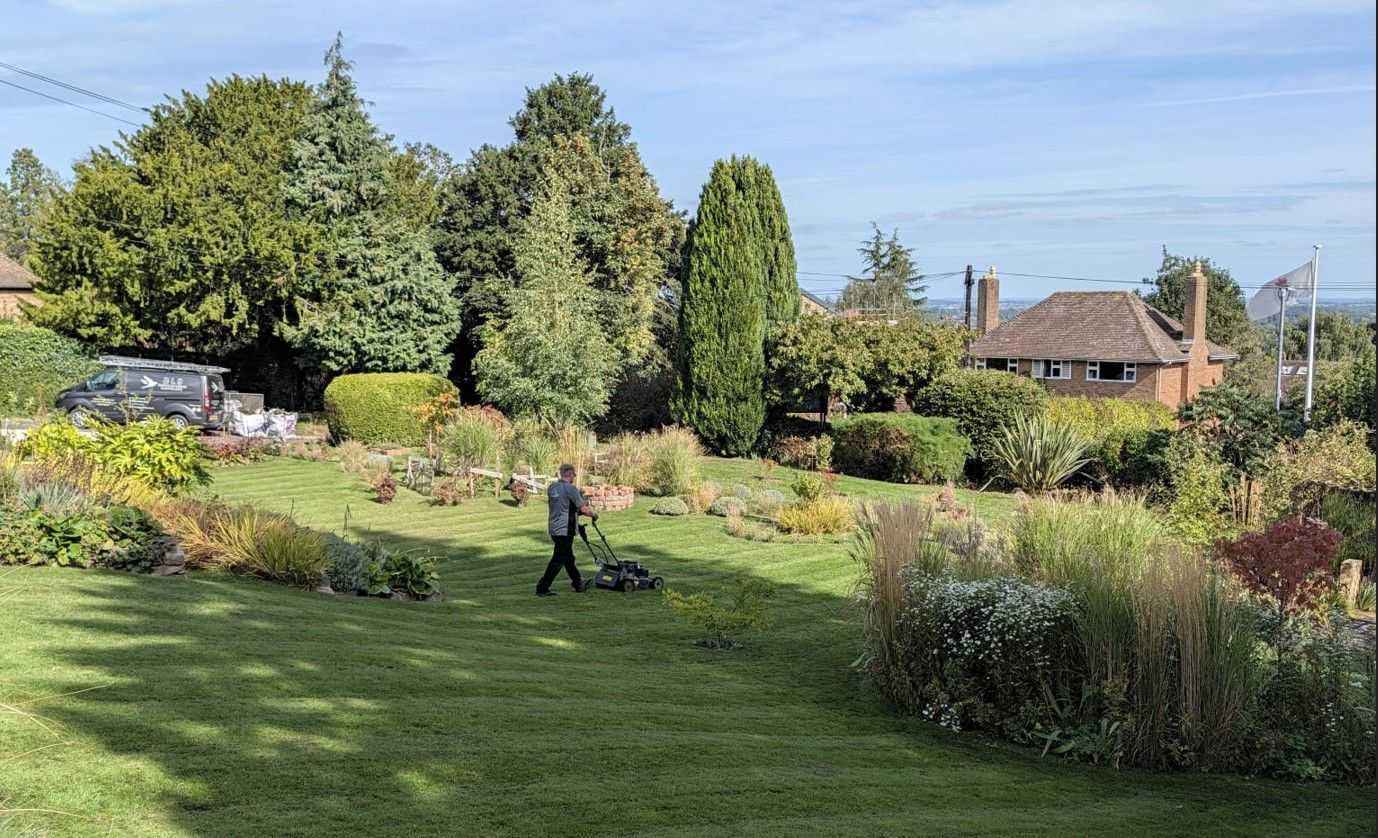 Man creating, freshly striped grass an care home